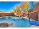 The pool boasts a waterfall feature and is equipped with a basketball hoop for added recreational fun at 10466 Smokewood Rd, Las Vegas, NV 89135