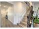 Inviting entryway with staircase featuring decorative iron spindles and neutral-toned wood steps, blending style with functionality at 10466 Smokewood Rd, Las Vegas, NV 89135