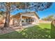 A well manicured backyard includes synthetic grass, trees, and a covered patio at 11125 Twilight Times Ct, Las Vegas, NV 89135