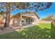 A well manicured backyard includes synthetic grass, trees, and a covered patio at 11125 Twilight Times Ct, Las Vegas, NV 89135
