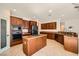 Spacious kitchen featuring brown cabinets, stainless steel appliances, and a granite island at 11125 Twilight Times Ct, Las Vegas, NV 89135