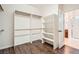 Walk-in closet featuring built-in shelving and wood floor in neutral color palette at 11125 Twilight Times Ct, Las Vegas, NV 89135