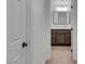 Hallway view into a well-lit bathroom with dark wood cabinetry and modern fixtures at 11775 Woodbrook Ct, Las Vegas, NV 89141