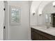 Bright bathroom featuring an undermount sink, custom cabinetry, and a window with white shutters at 11775 Woodbrook Ct, Las Vegas, NV 89141