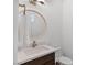 Bright half-bathroom featuring white walls, round mirror, granite countertops, and dark wood cabinets at 11775 Woodbrook Ct, Las Vegas, NV 89141
