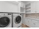 Modern laundry room with custom cabinets, granite countertops, and modern washer and dryer at 11775 Woodbrook Ct, Las Vegas, NV 89141