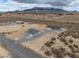 Wide aerial shot displaying a desert home with long driveway, detached garage, and mountain views at 1330 W Gee St, Pahrump, NV 89060