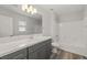 Bright bathroom featuring a white countertop, gray vanity, and white tiled shower at 1330 W Gee St, Pahrump, NV 89060