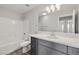 Modern bathroom with gray vanity, bright white countertops, and white tiled shower at 1330 W Gee St, Pahrump, NV 89060