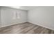 Clean and empty bedroom with wood-look flooring, a window, and neutral walls at 1330 W Gee St, Pahrump, NV 89060