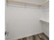 Walk-in closet, freshly painted, features wood closet rods and wood look flooring at 1330 W Gee St, Pahrump, NV 89060