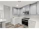 Bright kitchen featuring gray cabinets, quartz counters, stainless appliances, and wood flooring at 1330 W Gee St, Pahrump, NV 89060