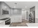 Bright kitchen with stainless appliances, white cabinets, quartz counters, and pantry at 1330 W Gee St, Pahrump, NV 89060
