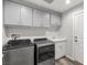 A laundry room featuring a washer and dryer, sink and white cabinets for a clean and organized space at 1330 W Gee St, Pahrump, NV 89060