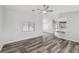 A spacious living room with new flooring, a ceiling fan and an open layout concept to the kitchen at 1330 W Gee St, Pahrump, NV 89060