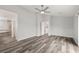 Spacious main bedroom featuring modern ceiling fan, grey-toned wood flooring, and ensuite bathroom access at 1330 W Gee St, Pahrump, NV 89060