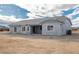 View of back exterior with sliding glass door, windows, and access to a concrete patio area at 1330 W Gee St, Pahrump, NV 89060
