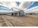 Rear exterior showcasing backyard with a patio, desert landscape, and matching detached building at 1330 W Gee St, Pahrump, NV 89060
