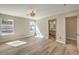 Bright bedroom with wood-look flooring, large windows, and a modern light fixture at 1665 Rowan Tree Dr, Las Vegas, NV 89123