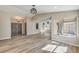 Open-concept living room showcasing wood-look tile floors and abundant natural light from large windows at 1665 Rowan Tree Dr, Las Vegas, NV 89123