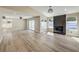 Bright living room with wood-look tile floors, a decorative fireplace, and large windows overlooking the backyard at 1665 Rowan Tree Dr, Las Vegas, NV 89123