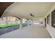 Covered patio showcasing arches, ceiling fans and adjacent synthetic lawn at 1904 Roxbury Ln, Las Vegas, NV 89119