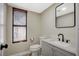 Modern bathroom featuring a gray vanity, black fixtures, and a stylish framed mirror at 1904 Roxbury Ln, Las Vegas, NV 89119