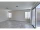 Bright bedroom with neutral walls, grey floors, natural light, and sliding glass door to outdoor patio at 1989 Bookbinder Dr, Las Vegas, NV 89108