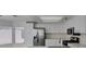 Kitchen with stainless appliances, white cabinets, stone countertops and gray wood-look flooring at 1989 Bookbinder Dr, Las Vegas, NV 89108