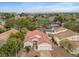 An aerial view showcases a red-tiled roof home nestled in a lush, green neighborhood with city views at 2008 Hobbyhorse Ave, Henderson, NV 89012
