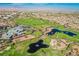 Sweeping aerial shot showcasing the golf course alongside water features and surrounding community amenities at 2147 Indigo Creek Ave, Henderson, NV 89012