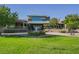 Community clubhouse featuring large windows, a manicured lawn, and a fountain centerpiece, creating a welcoming and attractive gathering spot at 2147 Indigo Creek Ave, Henderson, NV 89012