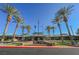 Beautiful entrance to the community center with palm trees, flags, and manicured flower beds at 2147 Indigo Creek Ave, Henderson, NV 89012