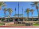 Impressive entrance of the community center, adorned with palm trees, flags, and lush landscaping at 2147 Indigo Creek Ave, Henderson, NV 89012