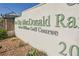 Close up of the Sun City MacDonald Ranch sign showcasing manicured landscaping and desert foliage at 2147 Indigo Creek Ave, Henderson, NV 89012