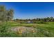 Picturesque golf course with a tranquil pond, fountain feature, lush greenery, and colorful flowers, providing a serene outdoor escape at 2147 Indigo Creek Ave, Henderson, NV 89012