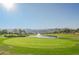 Scenic golf course with a pond, fountain, and mountain backdrop at 2147 Indigo Creek Ave, Henderson, NV 89012