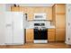 Well-maintained kitchen with oak cabinetry, white appliances, and an efficient layout at 2147 Indigo Creek Ave, Henderson, NV 89012