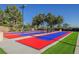 Outdoor shuffleboard court with colorful red and blue lanes and ample seating, perfect for community recreation and leisure at 2147 Indigo Creek Ave, Henderson, NV 89012