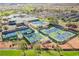 Aerial view highlights tennis and pickleball courts alongside clubhouse, pool and parking area within a Primary-planned community at 2147 Indigo Creek Ave, Henderson, NV 89012
