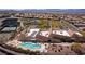 Beautiful aerial view of community clubhouse featuring a pool, tennis courts, and desert landscaping at 2151 Bannerwood St, Henderson, NV 89044