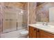 Cozy bathroom featuring a shower-tub combo with sliding glass doors and a vanity with maple-stained cabinets at 2151 Bannerwood St, Henderson, NV 89044