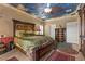 Bedroom with painted sky ceiling, large bed, rugs and tile flooring at 2151 Bannerwood St, Henderson, NV 89044