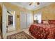 Bright bedroom with yellow walls, a ceiling fan, and a closet with sliding doors at 2151 Bannerwood St, Henderson, NV 89044