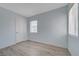 Bedroom with light blue walls, light grey wood-look flooring, a door and a window at 218 S Bruce St, Las Vegas, NV 89101