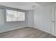 Light and airy bedroom with light blue walls and light grey wood-look flooring and bright window at 218 S Bruce St, Las Vegas, NV 89101