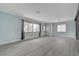 Spacious living room featuring grey wood-look floors, light blue walls and ample windows at 218 S Bruce St, Las Vegas, NV 89101