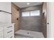 Modern bathroom with large tile shower, gray and wood-grain tile accents, and white vanity with black hardware at 2368 Winterwood Blvd, Las Vegas, NV 89142
