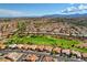 Community aerial view showcasing homes, lush green golf course and scenic mountain views at 3012 Anna Bay Dr, Las Vegas, NV 89134