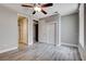 Bedroom featuring light gray walls, wood-look floors, access to bathroom, and a ceiling fan at 3012 Anna Bay Dr, Las Vegas, NV 89134